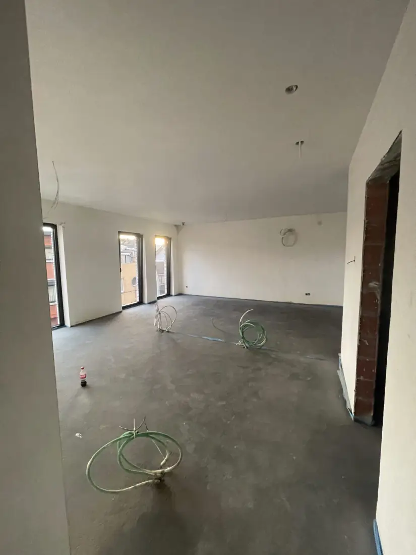 Ruime leefruimte met vers pleisterwerk en dekvloer