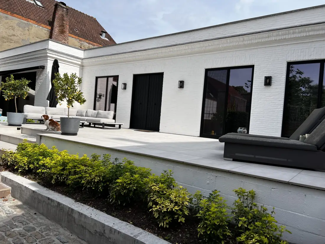 Het pand in Brugge met witgeschilderde gevel en terras boven de mancave