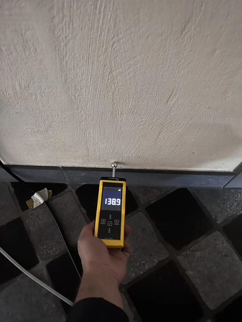 Vochtmeting op de witgepleisterde wand