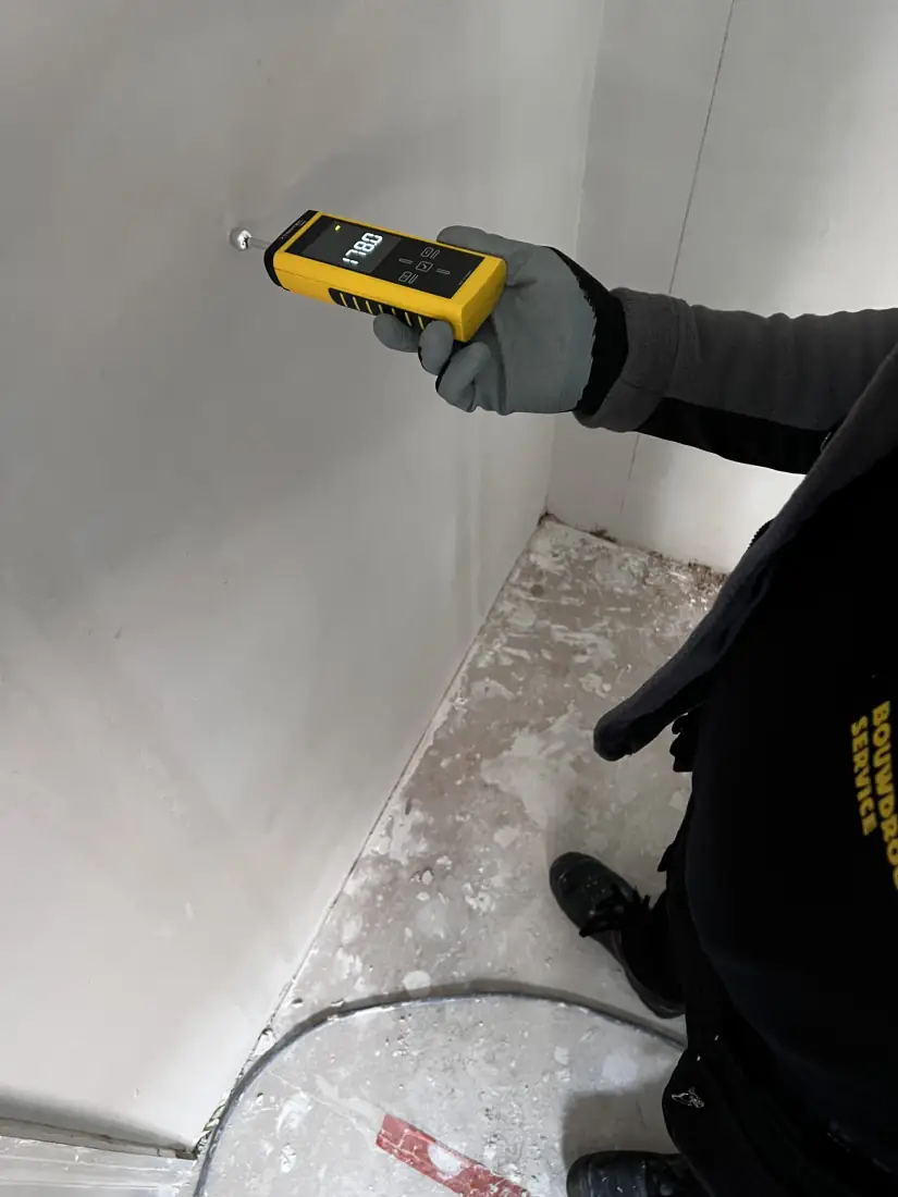 Technicus van Vernast meet het vochtgehalte van de wand