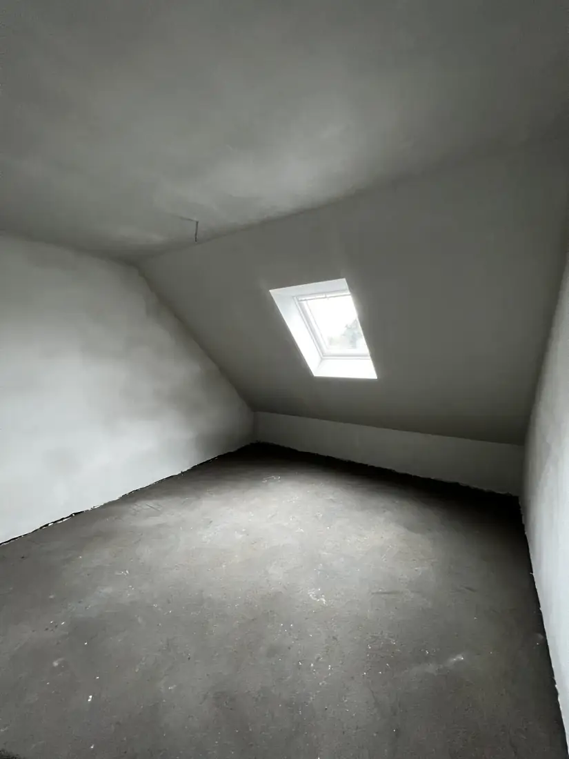 Kamer onder het dak met dakvenster in de nieuwbouwwoning