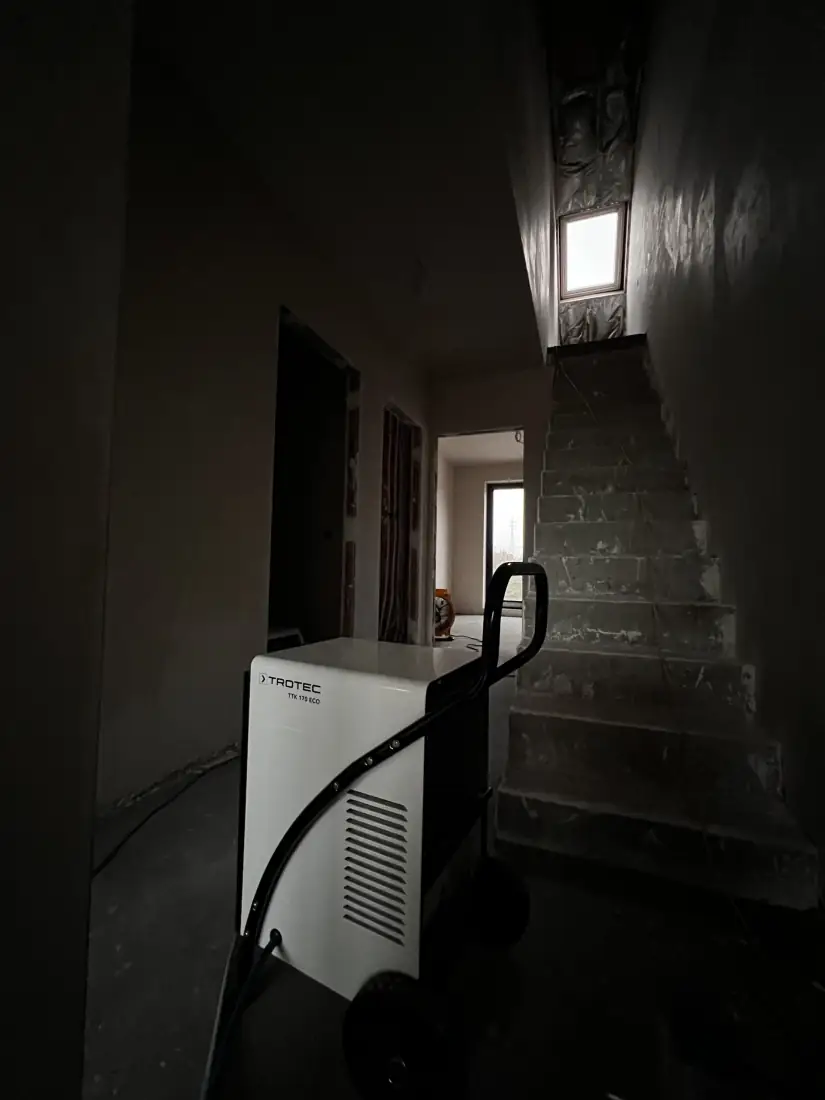 Bouwdroger onderaan de traphal in de woning