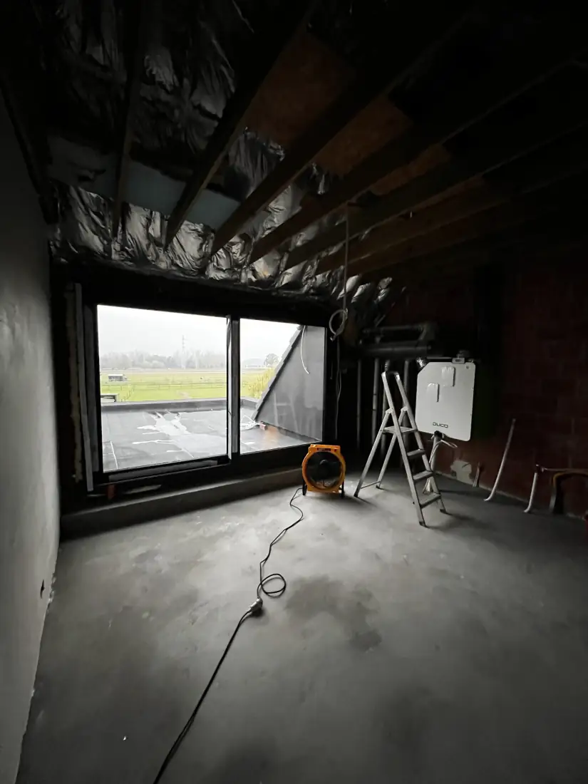 Ventilator aan het werk onder het hellende dak met isolatiefolie