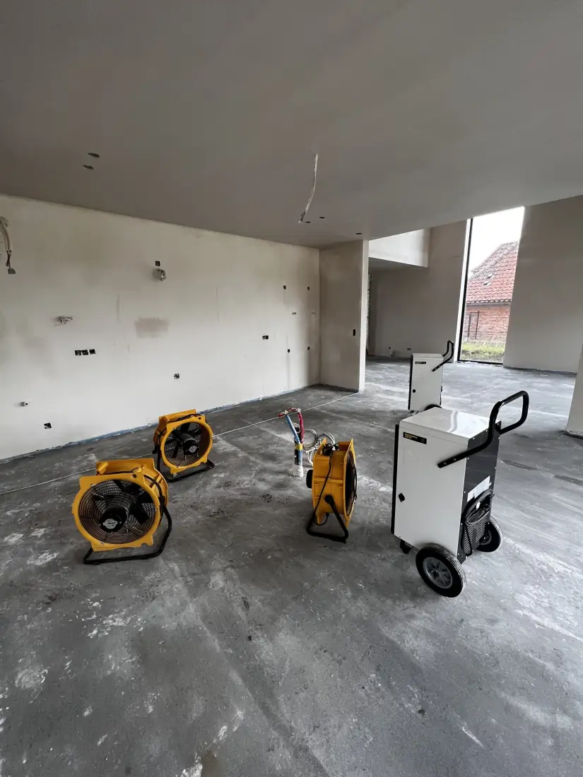Bouwdrogers en ventilatoren opgesteld in de leegstaande leefruimte