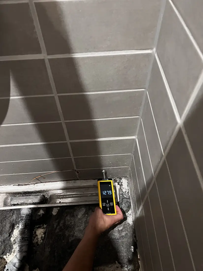 Meting in de tegelhoek van de badkamer boven de vrijgelegde leidingen